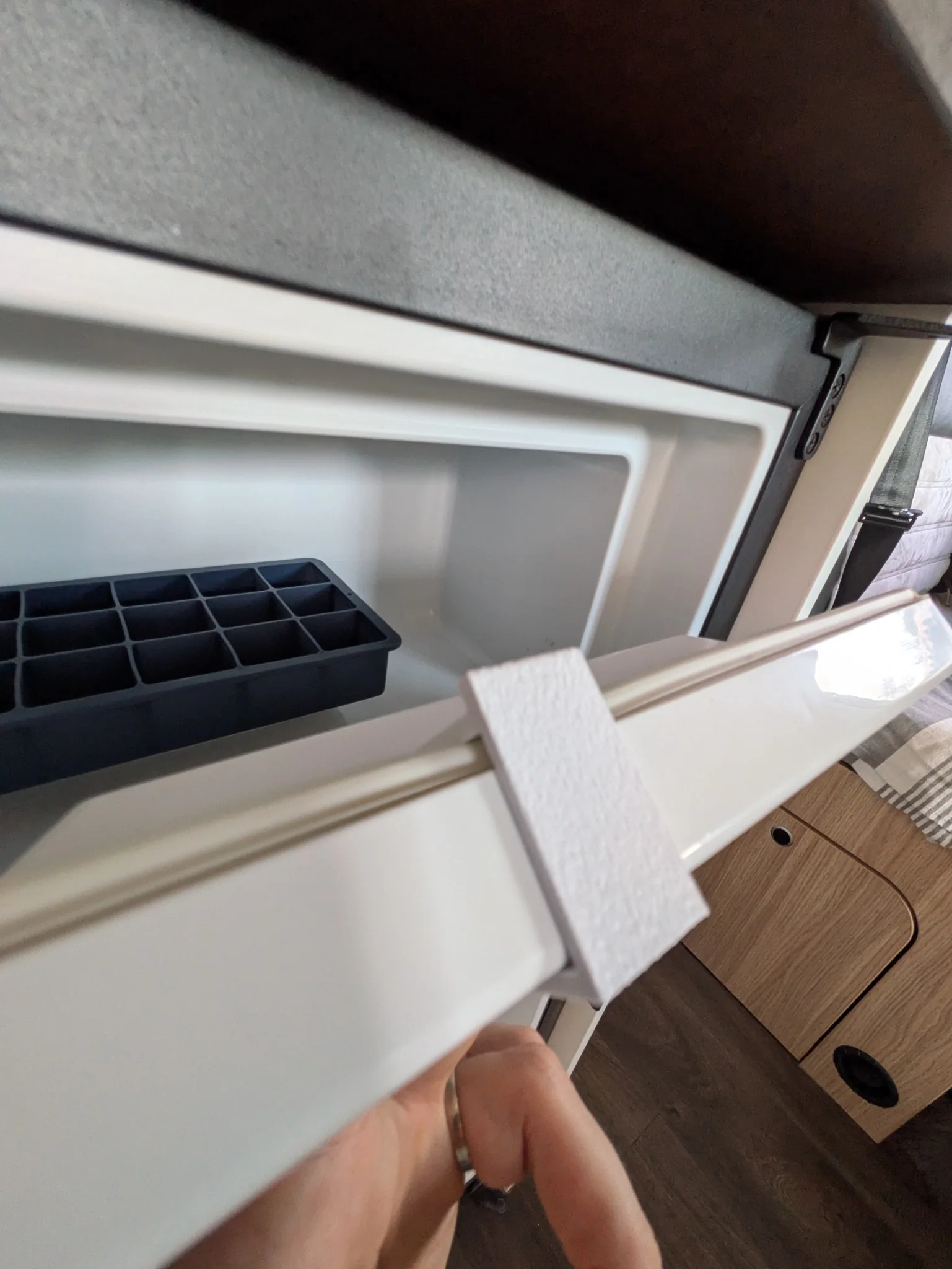 Porte du freezer Thetford T2090C entrouverte avec la cale de ventilation