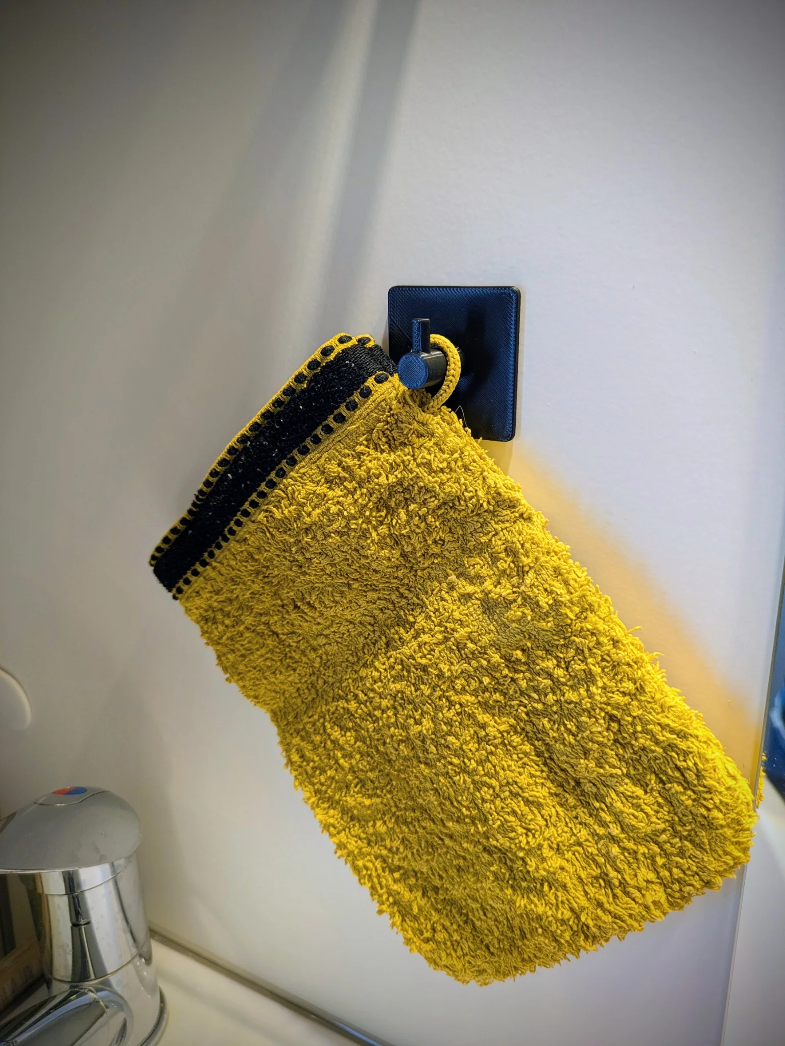 Crochet mural noir avec gant de toilette suspendu