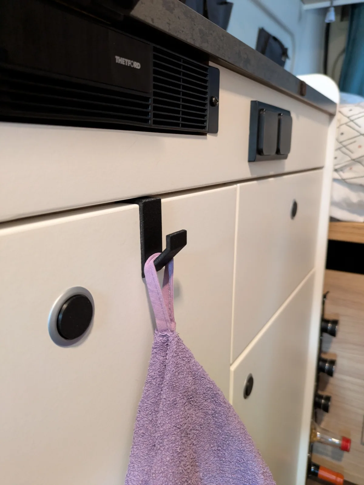 Détail du crochet de porte Fourgon Malin installé sur un placard