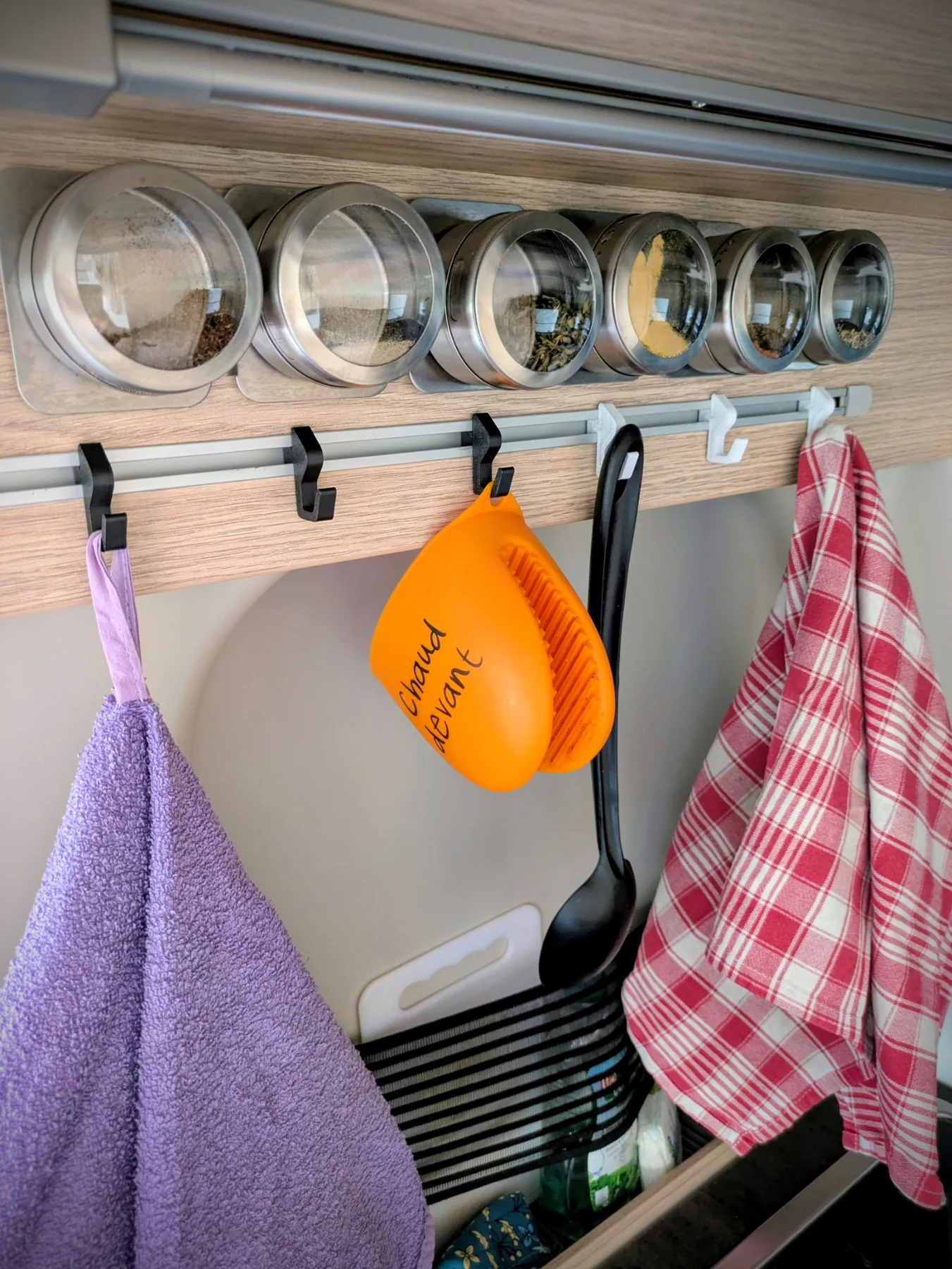Plusieurs crochets XL utilisés pour suspendre des accessoires dans un fourgon