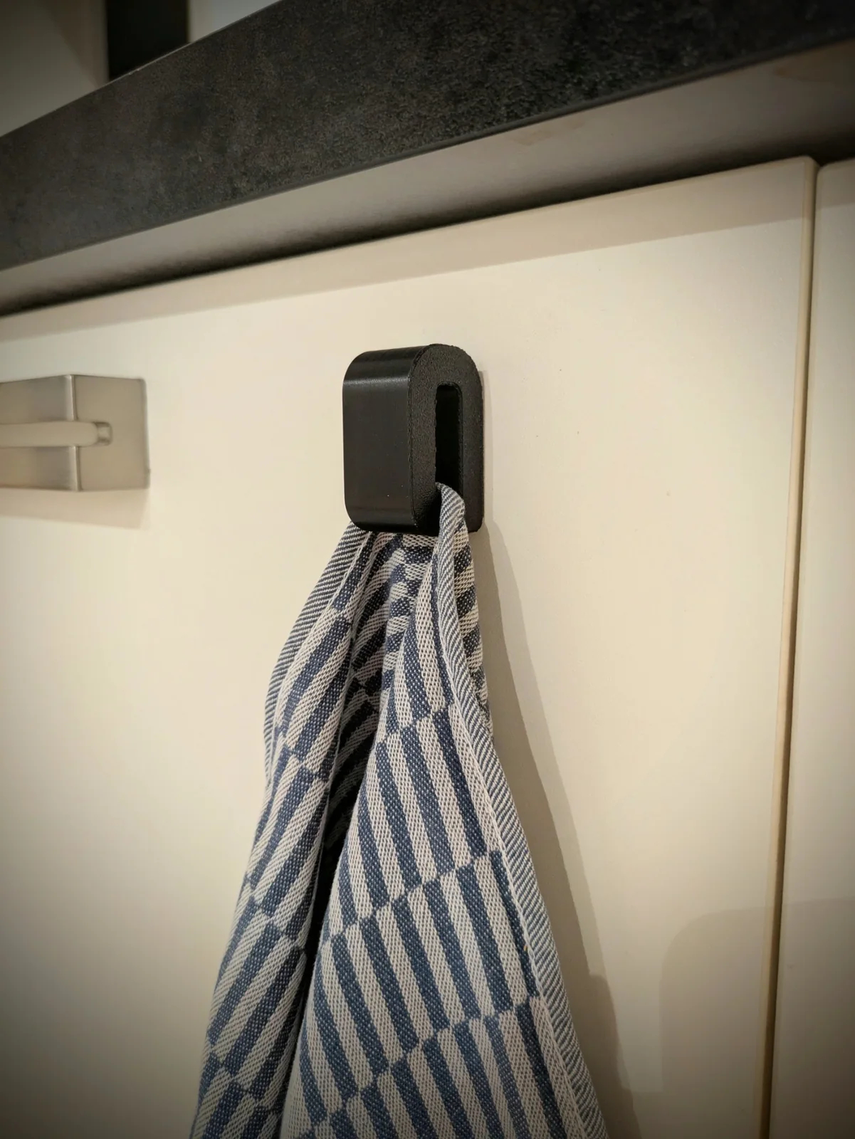 Porte-torchon noir utilisé avec un torchon dans la cuisine du fourgon