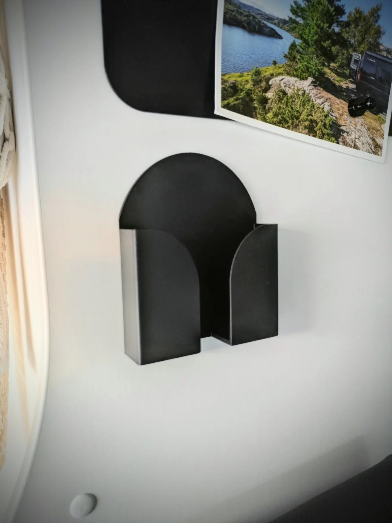 Support mural noir pour smartphone installé dans un fourgon aménagé