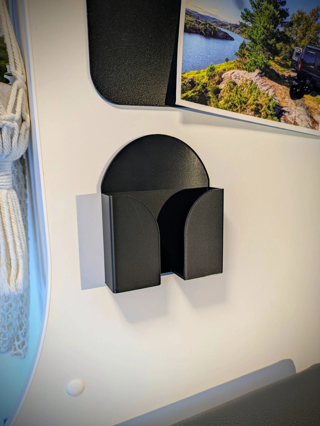 Support mural smartphone noir fixé sur une paroi de fourgon
